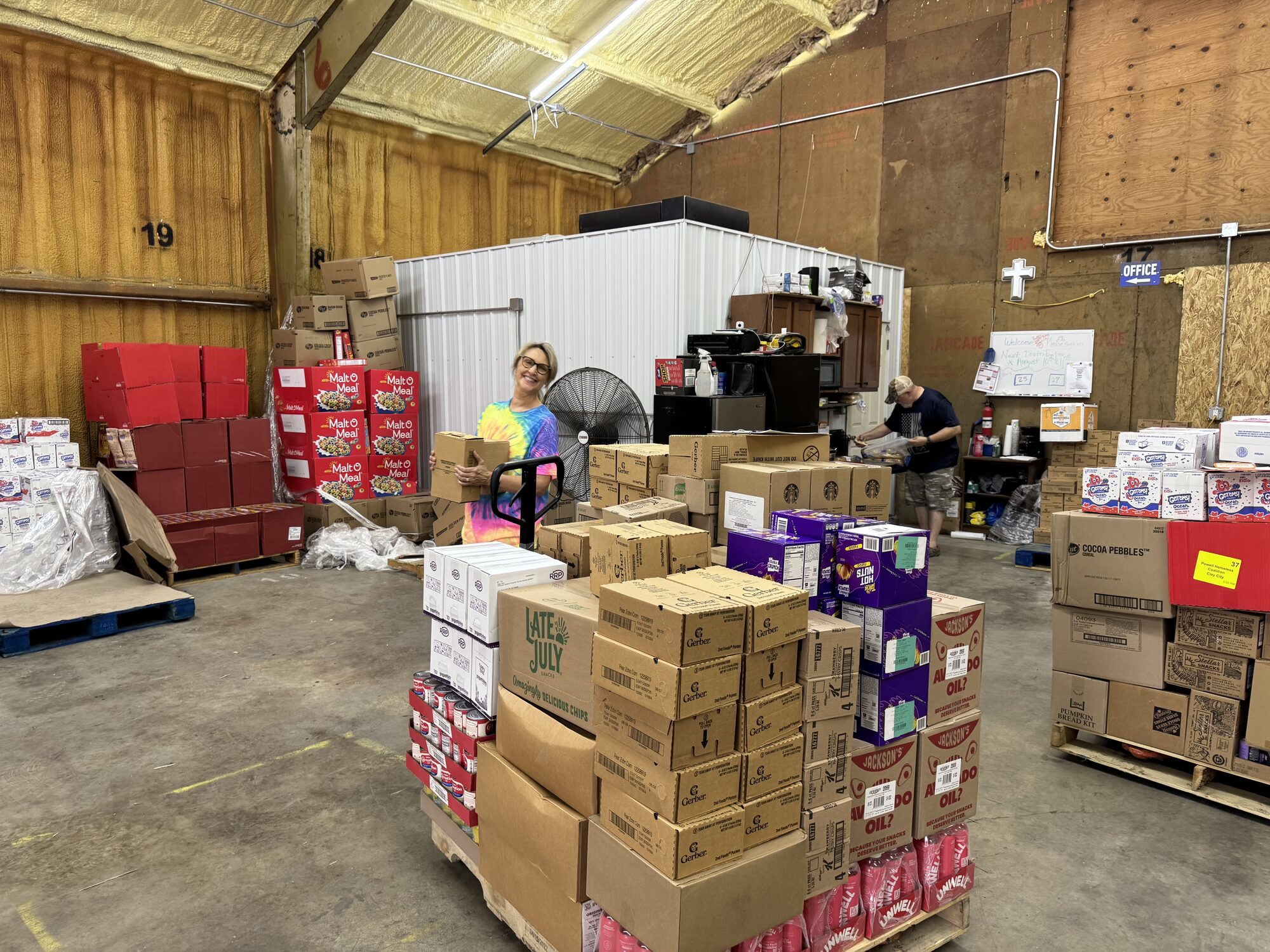 Neatly stacked boxes of groceries fill the warehouse aisles as volunteers prepare orders for partner agencies serving the Appalachian community.