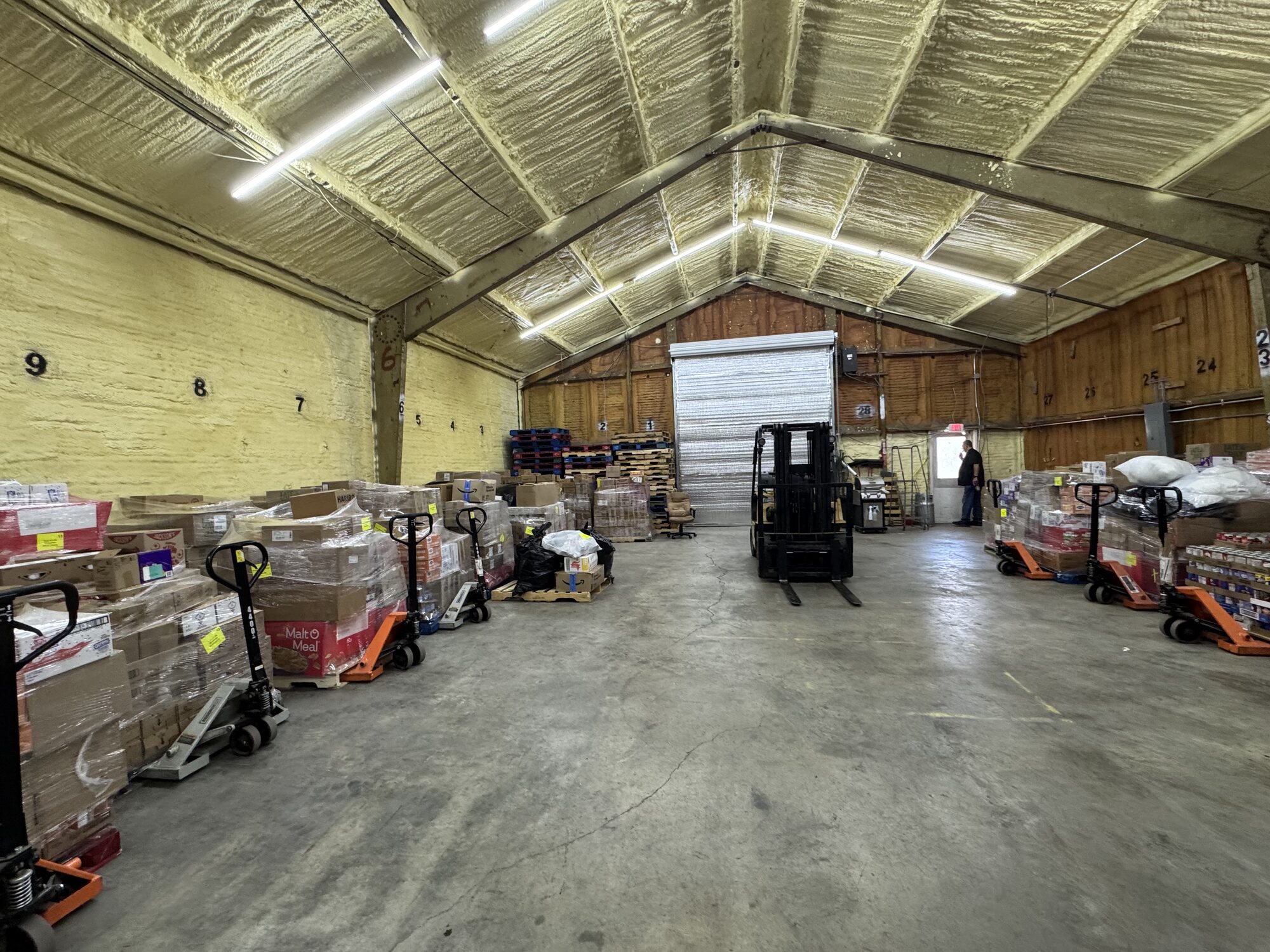 Boxes of donated food line the warehouse walls, ready to be loaded and delivered during the upcoming Clay City distribution.