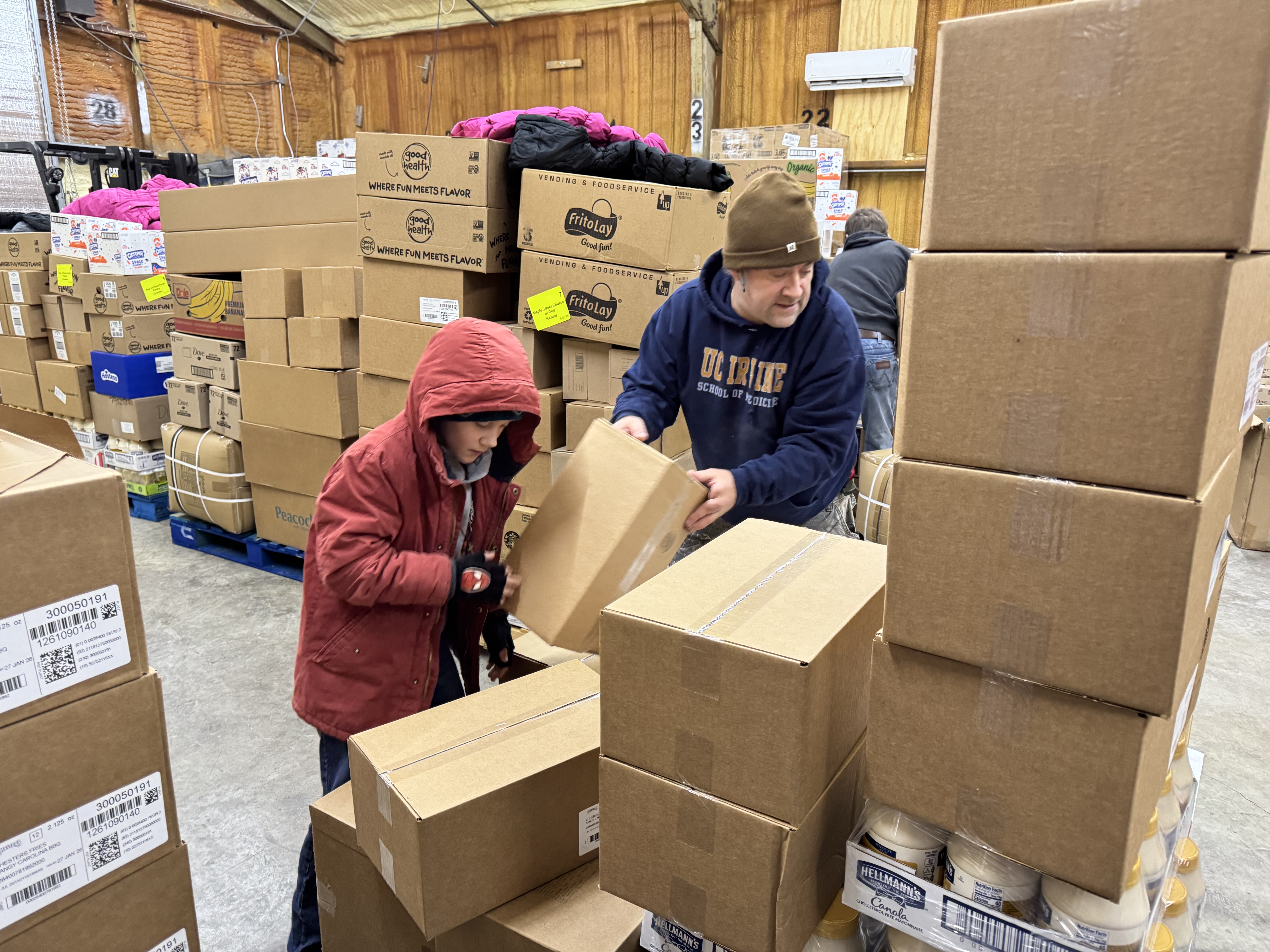 Our dedicated volunteers, young and old, are working together, thoughtfully organizing boxes to ensure food reaches those in need. Every box moved is a step closer to serving our community with love and nourishment.
